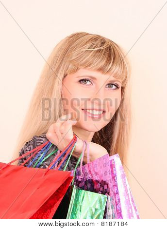 Krásná mladá žena s Color nákupní tašky v ruce na bílém pozadí.
