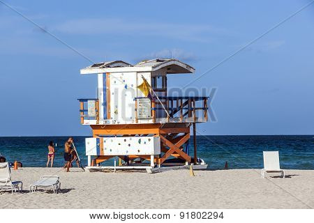 People Enjoy The Beach Next To A Lifeguard Tower