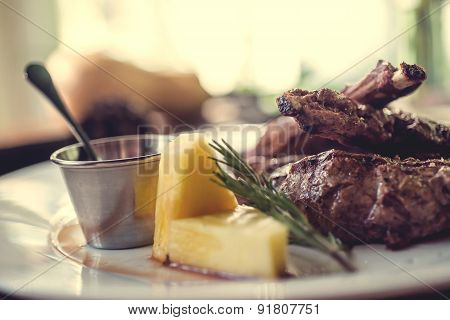 Close up of grilled pork ribs with lemon, sauce and rosmary. Selective Focus. Autumn concept decorat