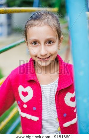 Cute little girl is playing in playground, outdoor shoot