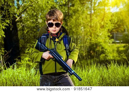 A boy playing with a toy rifle outdoor. Military concept. Childhood.