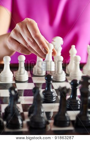 Hand With White Pawn Over Chessboard