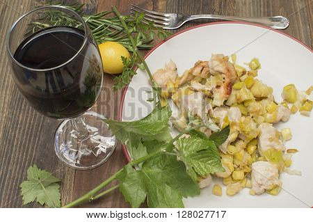 chicken with leeks , sauteed leeks fried chicken with a glass of wine , vine leaves