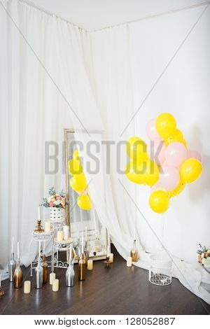 pink and yellow ballons with flowers on the white wall in studio