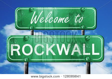 rockwall vintage green road sign with blue sky background