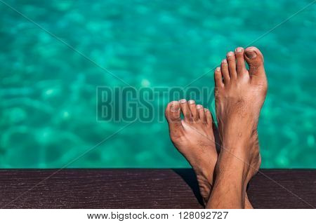 A shot of relaxation gesture with crossed legs overlooking the ocean.