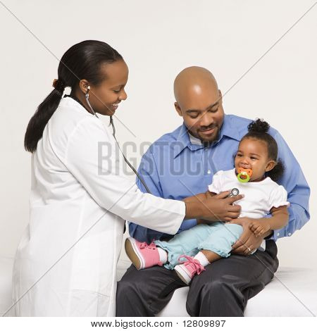 Afro-americano femminile pediatra esaminante bambina detenuta dal padre.