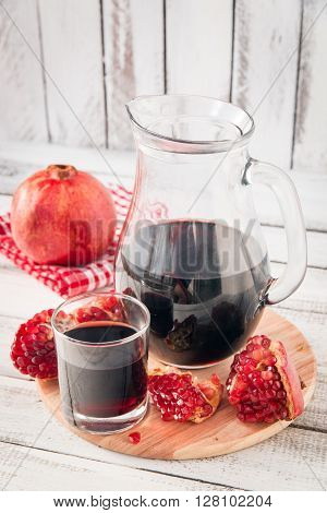 glass of pomegranate juice with fresh fruits on wooden table
