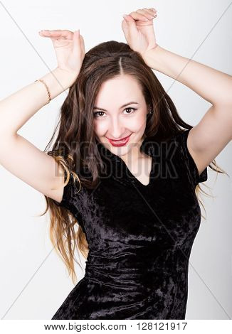 Portrait of a funny casual woman showing rabbit geture over his head. different happy emotions..