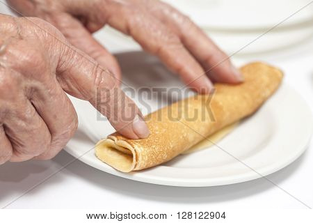 View of a woman hand rolling up a crepe