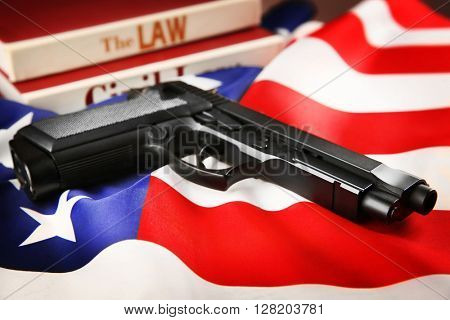 Gun and books of civil law on USA flag background