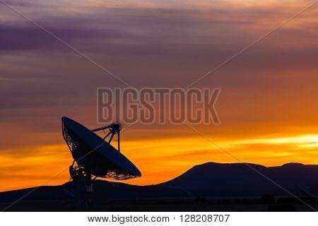 Sunset in the high desert of New Mexico, featuring a radio telescope