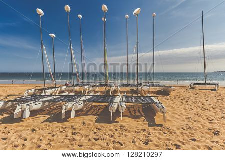 Catamaran empty. Catamaran stored on beach in La Baule France on blue sky.