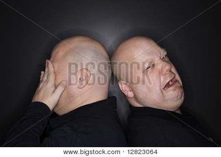 Caucasiano careca meados homens adultos gêmeos idênticos permanente voltar para trás com expressões tristes.