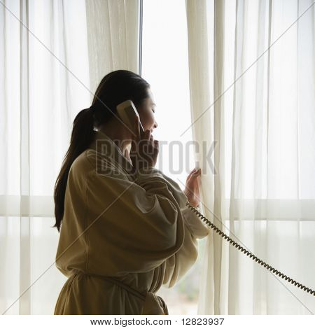 전화 통화 하 고 창 밖을 보면서 목욕 가운 성인 여자 중반 대만.