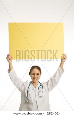 Porträt des kaukasischen Mid Ärztin halten leer gelbes Schild lächelnd und Blick auf vi