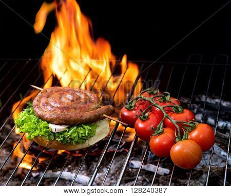 grill concept with flame. Burger and sausages on a grill pan.