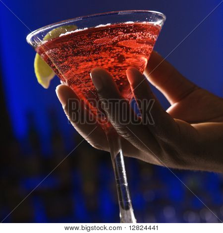 Afroamerické muže ruka drží martini v barech zářící modré pozadí.