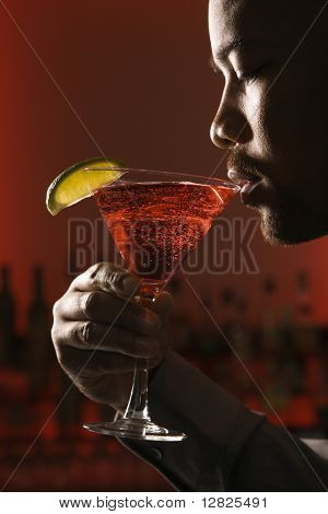 Afroamerické muže pít martini v barech proti červeným pozadím.