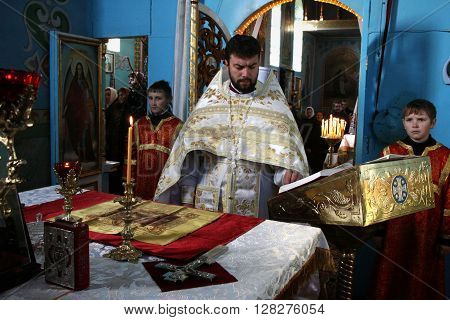 VOYUTYN UKRAINE - JANUARY 08: Orthodox priest and little sexton during Christmas service in Voyutyn on January 08 2009.