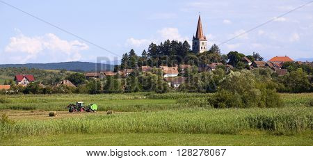 Idyllic rural view of gently rolling patchwork farmland and village in the summer