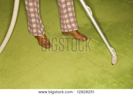 Nahaufnahme der kaukasischen männliche Füße mit Vakuum-Erweiterung gegen Grün retro Teppich.