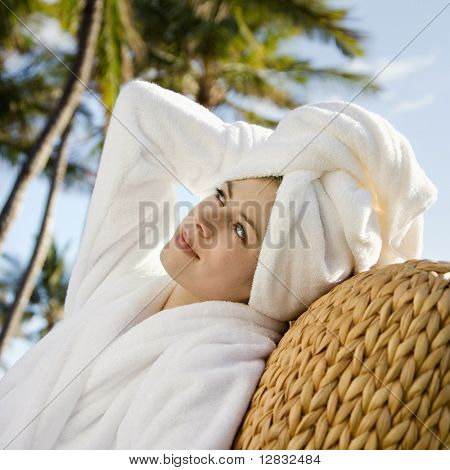 Kaukasische mid-adult vrouw dragen gewaad en handdoek op hoofd met hand aan het hoofd.