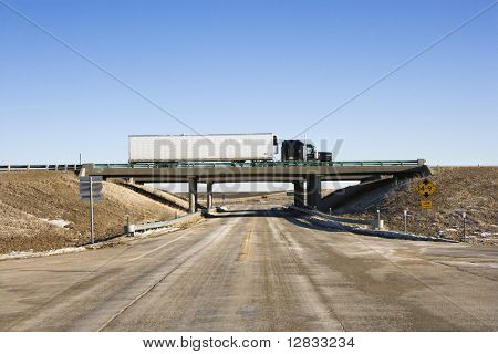 Tractor trailer truck on overpass.