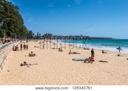 Sydney Australia - November 9 2014: Manly Beach on a sunny sunday morning with tourists and sightseers enjoying the water Sydney Australia. People having fun on Manly beach.
