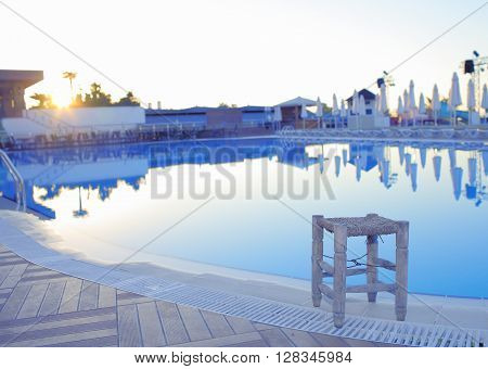 Rest at the empty hotel pool in the sunrise
