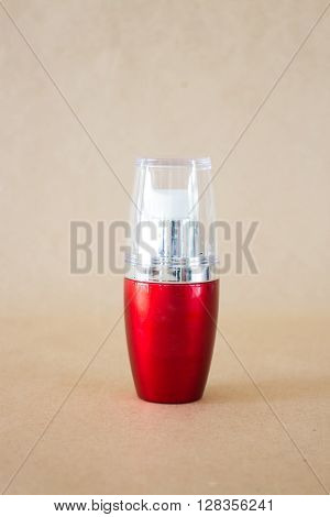 Shiny hard red bottle on brown background stock photo