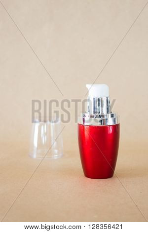Shiny hard red bottle on brown background stock photo