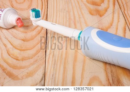 Electric Toothbrush on a light wooden background.