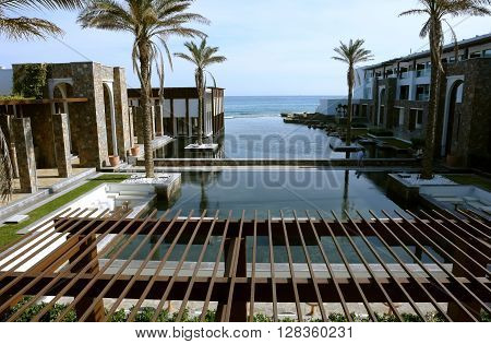 HERAKLION, CRETE, GREECE - MAY 13 2014: The big blue swimming-pool with palms and beach in luxury class hotel Grecotel Amirandes, May 13, 2014, Greece.
