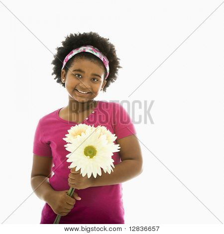 African American girl innehar stora Gerbera Daisies leende på viewer.