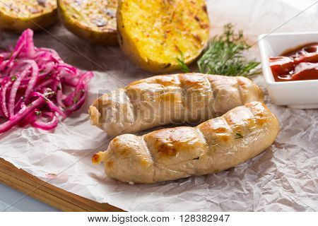macro meat kupaty with fries and greens on white plate. potato