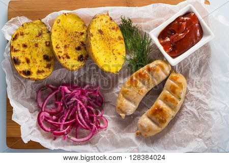 macro meat kupaty with fries and greens on white plate. potato