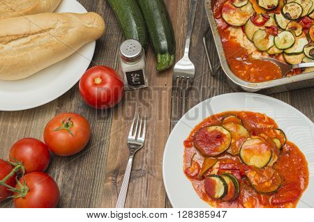 zucchini gratin , baked , with tomatoes,zucchinis and fresh tomatoes on the table