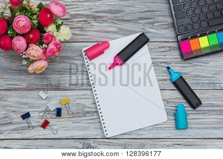 stationery flowers and notepad on old boards flat lay