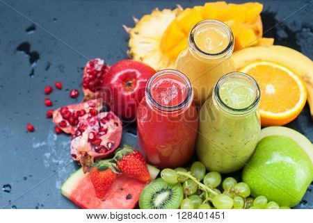 Fresh Juices Smoothie Three Bottles Red Green Orange Tropical Fruits Water Melon Strawberry Apple Kiwi Grapes Orange Mango Banana Pine Apple Pomegranate Grape Selective focus