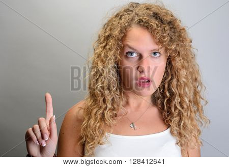 Wondered Woman Pointing Up With Finger And Asking Wtf