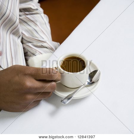 African American męskiej dłoni trzymając uchwyt expresso filiżanka.