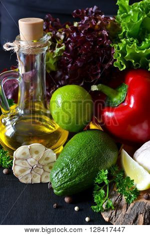 Fresh ripe vegetables olive oil lettuce on a black background