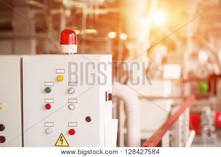 Control panel with rotating light. Buttons and switches on panel. Machine that distributes energy. Good knowledge is required.