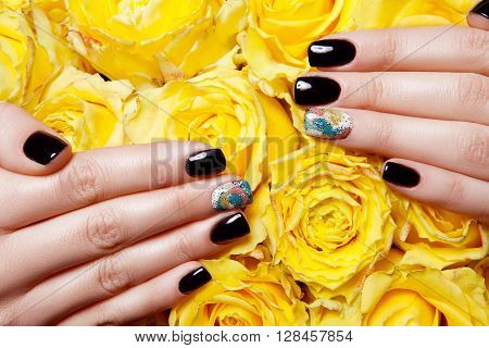 Close Up of FClose Up of Female Hands Wearing Bright Polish on Nails and Holding Yellow Roses - Spa Manicure Detailemale
