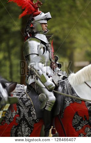 Harcourt France - April 23 2016: An unidentified man in a suit of armour is riding his horse to a mediaeval jousting tournament on Apr. 23 2016 in Harcourt France. It takes place in front of the castle Harcourt