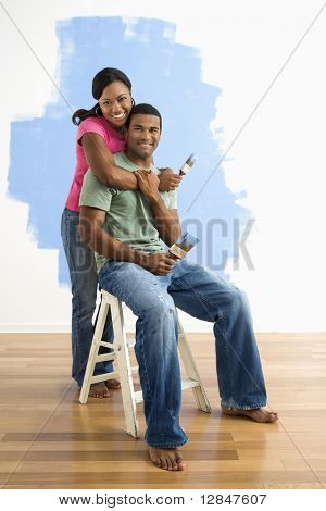 Portrét afrických amerických mužů a žen pár vedle napůl malované zdi.