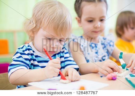kids group learning arts and crafts in kindergarten together