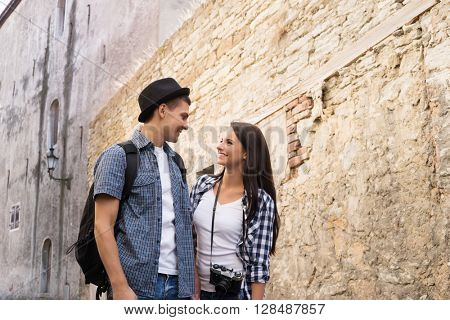 Beautiful, smiling couple having a pleasant walk in old town.