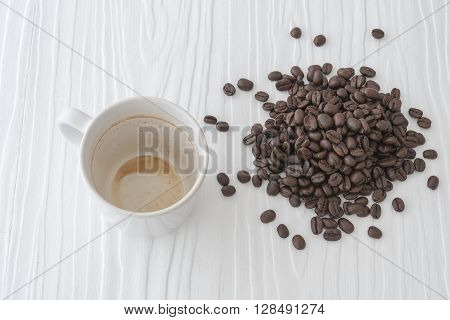 Coffee Cup And Beans With Coffee Stains Have Not Washed The Cup Placed On The White Table